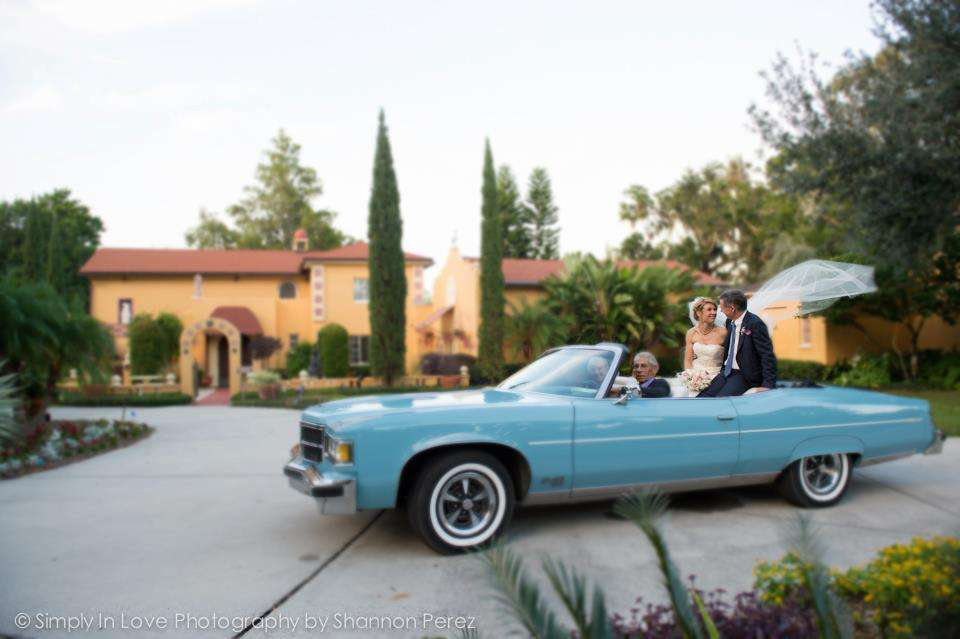 Photo of a car pulling away with the bride and groom at the Cape House at Albin Polasek Museum and Sculpture Gardens, a venue in Winter Park, FL 